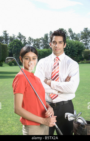 Couple standing in a golf course Stock Photo