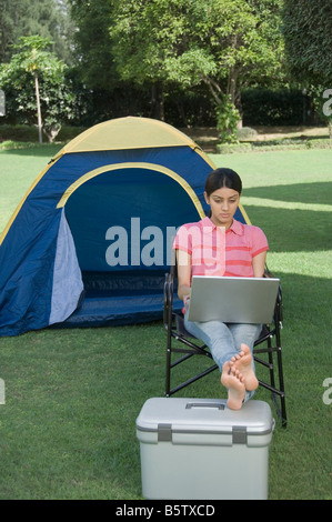 Woman using a laptop in a park Stock Photo