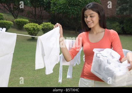Woman removing dried cloth from clothesline Stock Photo