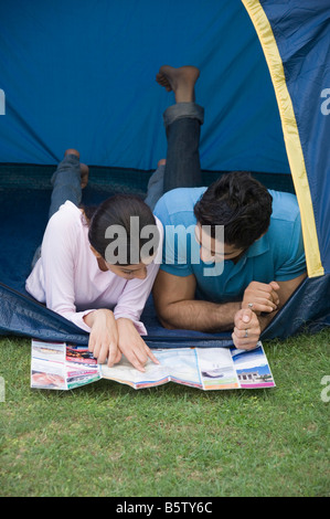 Couple reading a brochure in a tent Stock Photo