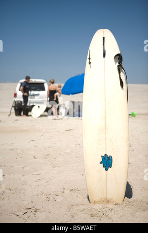 Surfboard stuck in the sand Stock Photo