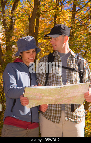 Young couple consulting a map while hiking amid the autumn colors on the Temple Quarry Trail in Little Cottonwood Canyon Wasatch Stock Photo