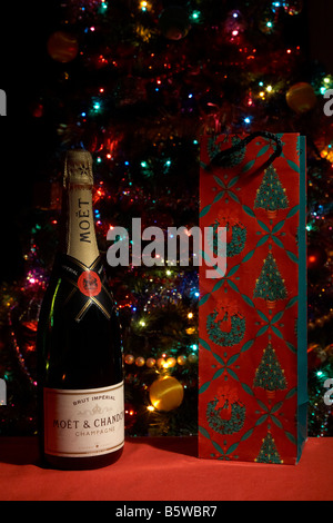 bottle of moet and chandon champagne with christmas bottle wrapping in front of christmas tree Stock Photo