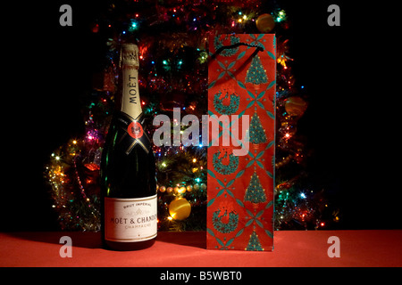 bottle of moet and chandon champagne with christmas bottle wrapping in front of christmas tree Stock Photo