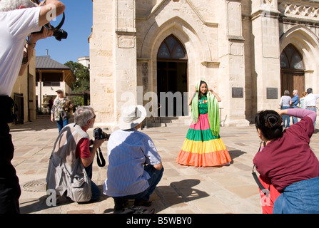 San Antonio Founder's Day young Hispanic woman in traditional dress being photographed in San Fernando Cathedral Plaza Stock Photo