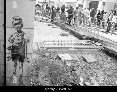 Market Street, Oxford, England 2004: graffiti stencil of Diane Arbus Boy with Hand Grenade painted on a building site wall Stock Photo