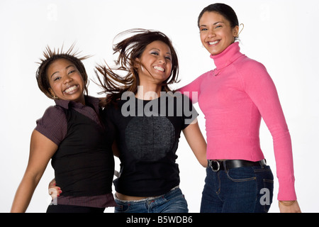 Asian Black and Latino young women laughing and jumping together on a white background Stock Photo