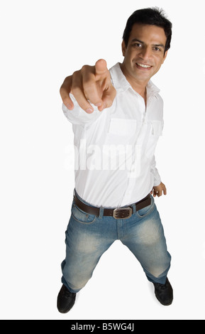 Portrait of a young man smiling and pointing Stock Photo