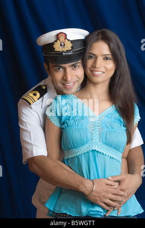 Portrait of a navy officer embracing a teenage girl from behind Stock Photo