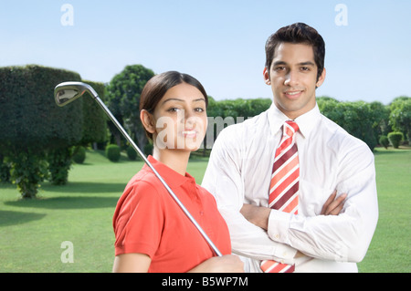 Couple in a golf course and smiling Stock Photo