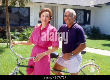 Senior Hispanic couple rides tandem bike Stock Photo