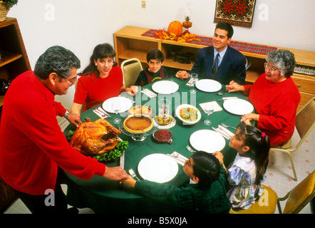 Hispanic family prays before Thanksgiving dinner. Stock Photo
