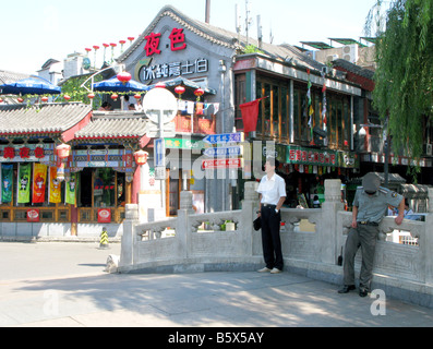 A policeman and tourist on the Jin Dynasty Yinding bridge near The Skewed Tobacco Pouch Street Stock Photo