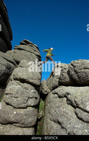 A girl jumping over rocks on Haytor on Dartmoor Stock Photo