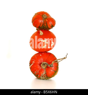 Three orange coloured stacked pumpkins on isolated white background Stock Photo