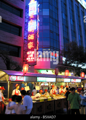 Serving food at Donganmen night Market stall in Beijing Stock Photo