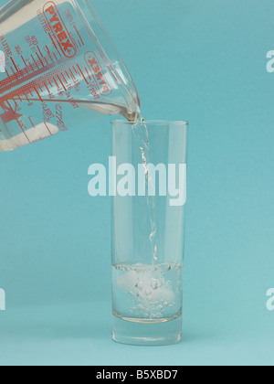 Pouring Water into a Glass on with Ice Cube Stock Photo