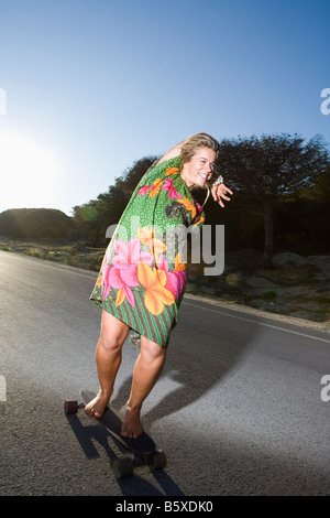 Young woman skateboarding barefoot Stock Photo