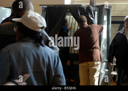 An election worker assists a voter in the operation of the machine in the Harlem neighborhood of New York on Election Day Stock Photo
