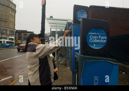 A commuter purchases her fare at a Select Bus Service kiosk in the New York borough of the Bronx Stock Photo