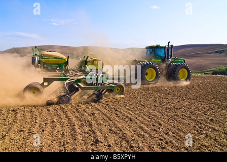 A tractor pulls an air seeder to plant garbanzo beans in the spring in the Palouse region of Washington Stock Photo