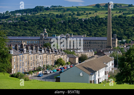 Historic impressive Victorian textile mill (art gallery) in Aire valley, tall chimney towering over houses - Salt Mill, Saltaire, England, GB, UK. Stock Photo