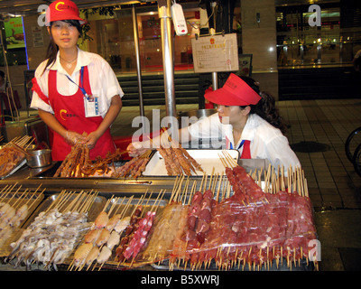 Serving food at Donganmen night Market stall in Beijing Stock Photo