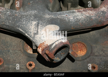 Automobile engine detail showing exhaust manifold to exhaust pipe connection point Stock Photo