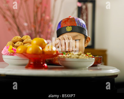 boy enjoying himself with candies during chinese new year Stock Photo