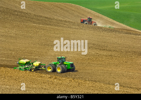 A tractor pulls an air seeder to plant grains or legumes n the spring in the Palouse region of Washington Stock Photo