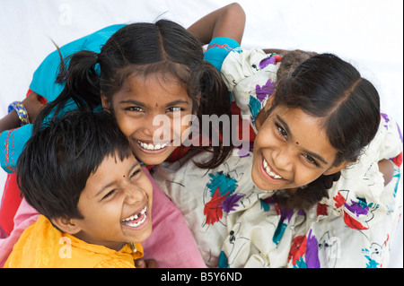 Three indian girl friends sitting together laughing at camera.  Andhra Pradesh, India Stock Photo