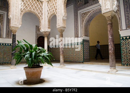 A tourist walks past the Patio de las Munecas, decorated with colored tiles and stucco arabesques, in the Alcazar, Sevilla, Andalusia, Spain. Stock Photo