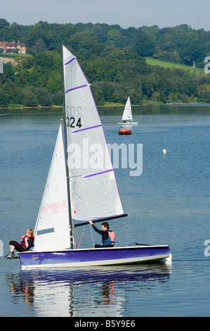 Man and Boy on a small Sailing boat Dinghy at Ardingly Reservoir West Sussex Stock Photo