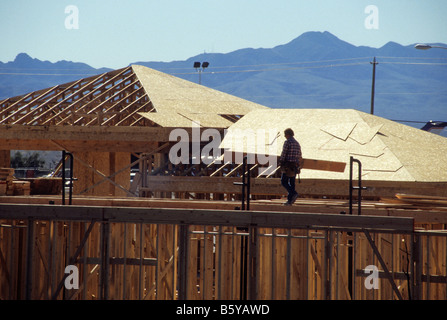 Workers install roof panels on new construction. Stock Photo
