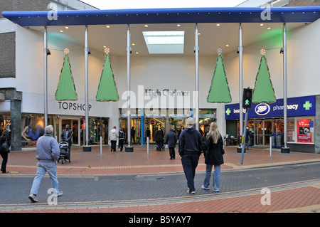Street scene back view of shoppers walking towards Chelmsford town centre entrance to High Chelmer shopping mall with Christmas decorations Stock Photo