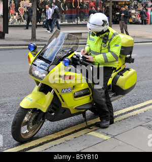 Motorbike paramedic completes paperwork after responding to emergency call to West End shopping street Oxford Street London England UK Stock Photo