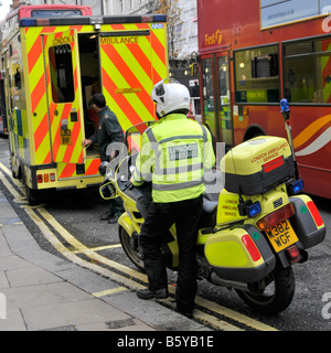 London Oxford Street ambulance & back view motorbike paramedic respond to emergency call to this busy West End shopping street England UK Stock Photo