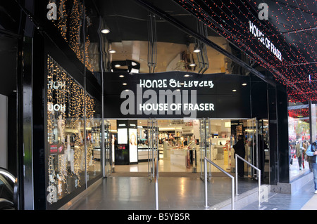 Christmas lights & shopping at  House of Fraser department store entrance Oxford Street shopper at entrance at Xmas time West End London England UK Stock Photo