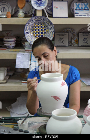 Woman painting at Ceramica vieira pottery in Lagoa, Azores, Portugal. The redish colour becomes blue in the burning oven. Stock Photo