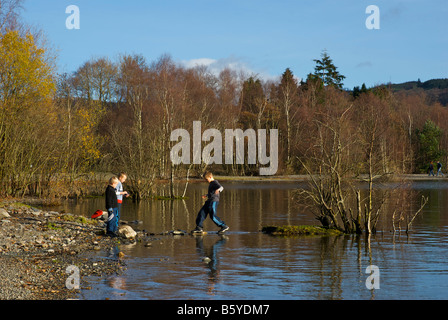 Three boys playing on the shore of Coniston, Lake District National Park, Cumbria, England UK Three boys playing on the shore of Coniston, Lake District National Park, Cumbria, England UK