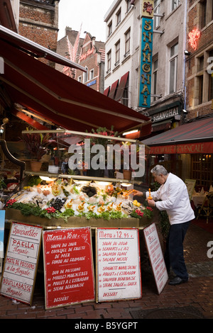 Waiter prepares pavement display of shellfish and seafood on ice outside a seafood restaurant in Brussels. Belgium. (44) Stock Photo