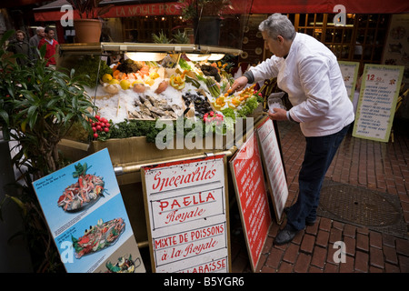 Waiter prepares pavement display of shellfish and seafood on ice outside a seafood restaurant in Brussels. Belgium. (44) Stock Photo