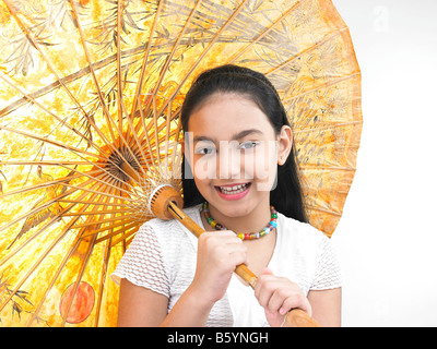 a pretty Asian girl smiling and holding a traditional oriental umbrella Stock Photo