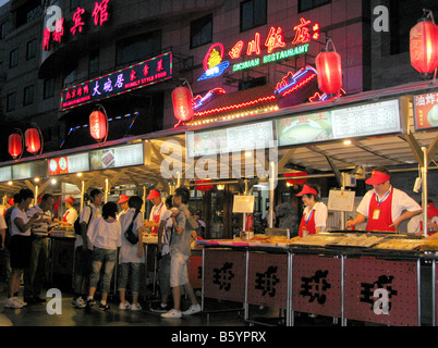 Serving food at Donganmen night Market stall in Beijing Stock Photo