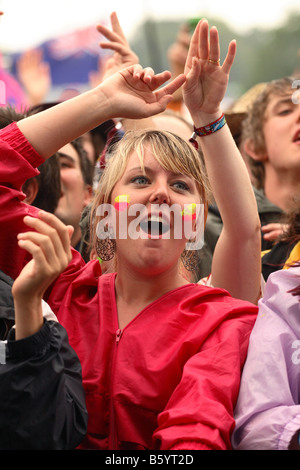 Glastonbury Festival 2008 pop music girl female fan in the crowd watching and dancing listening to The Feeling band on stage Stock Photo