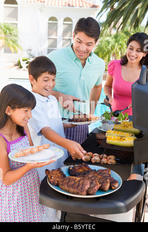 Family Enjoying A Barbeque Stock Photo