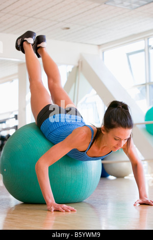 Woman Doing Push Ups On Swiss Ball At Gym Stock Photo