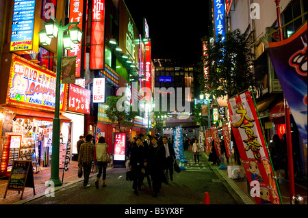 Shoppers at night in Shinjuku, Tokyo, Japan Stock Photo