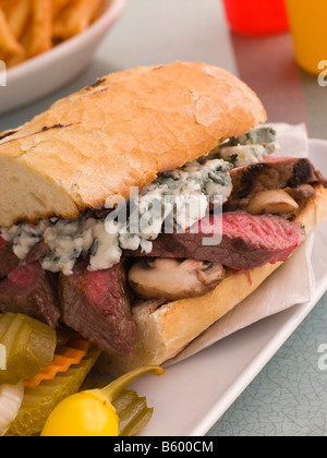 Steak and Roquefort Sandwich with Fries Gherkins and Chillies Stock Photo