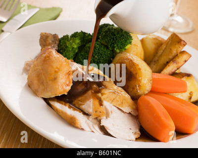 Gravy being Poured over a plate of Roast Chicken Stock Photo